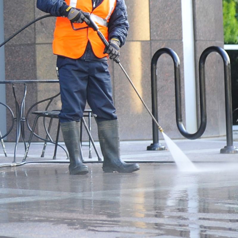 Professional pressure washing a concrete sidewalk